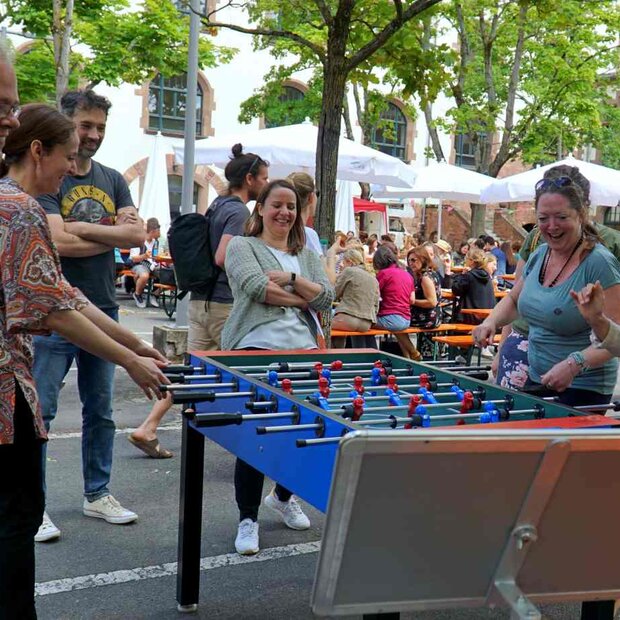 Mitarbeitende spielen Tischkicker im innenhof der PH.