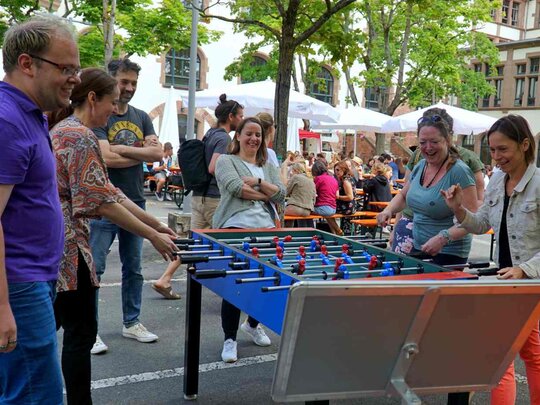 Mitarbeitende spielen Tischkicker im innenhof der PH.