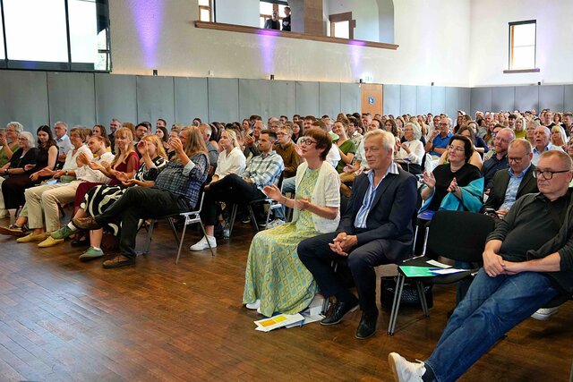 Zu sehen ist das Publikum von vorne.