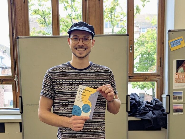 Das Bild zeigt den Hiwi der Sprecherziehung, Gabriel, auf dem Markt der Möglichkeiten