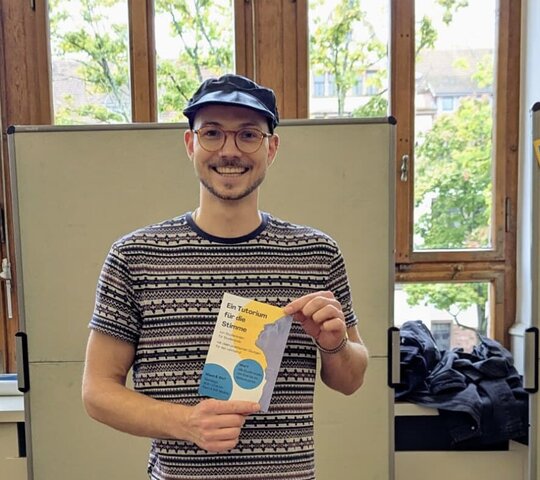 Das Bild zeigt den Hiwi der Sprecherziehung, Gabriel, auf dem Markt der Möglichkeiten