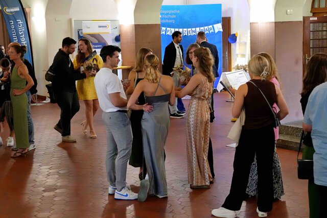 Zu sehen ist eine Gruppe von Alumni & Gästen im Foyer der PHHD während des Sektempangs.