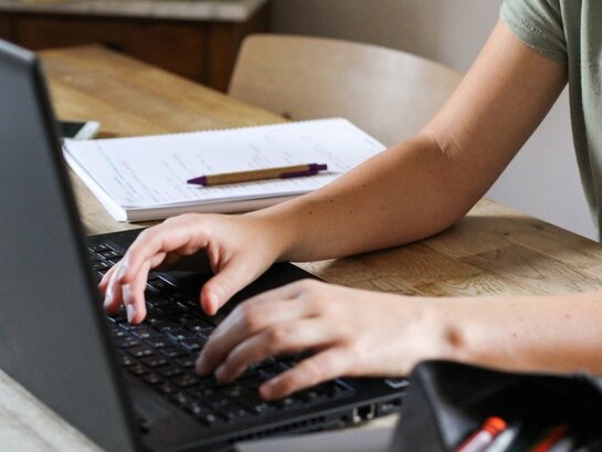 Das Foto zeigt Hände auf einer Laptoptastatur.