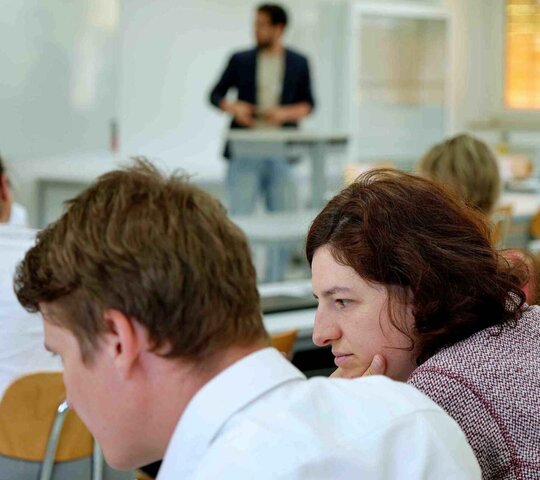 Zwei Personen nehmen an einem Vortrag teil. 