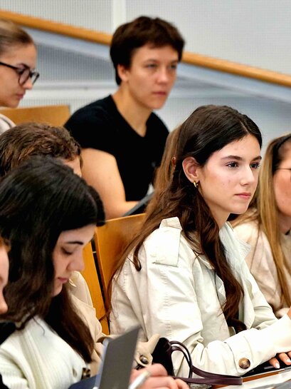Zu sehen ist eine Gruppe Studierender in einem Hörsaal.