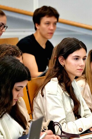 Zu sehen ist eine Gruppe Studierender in einem Hörsaal.