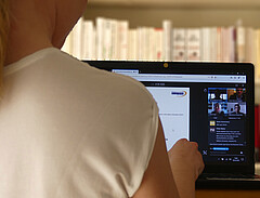 Das Bild zeigt eine Frau vor einem Laptop auf dessen Bildschirm man die digitale Informationsveranstaltung aus dem Sommersemester 2020 sieht. Copyright: Pädagogische Hochschule Heidelberg