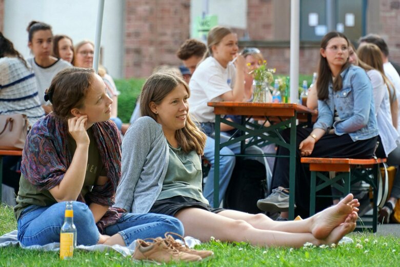 Zwei Frauen sitzen auf dem Rasen des Innenhofs der PH Heidleberg, Altbau. Sie symbolisieren das Leben am Campus, der über den Campus-Blog festgehalten wird. Der Campus-Blog wird von der Presse und Kommunikation redaktionell geführt.