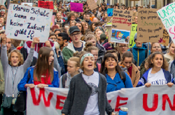 Auf dem Bild sieht man viele junge Menschen mit Plakaten die für den Klimaschutz demonstrieren.