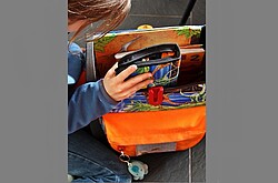 Das Foto zeigt ein Mädchen beim Einräumen ihres Schulranzen.