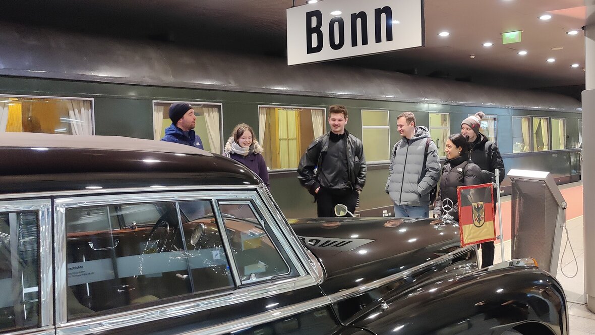 Foto von Studierenden an einem Auto