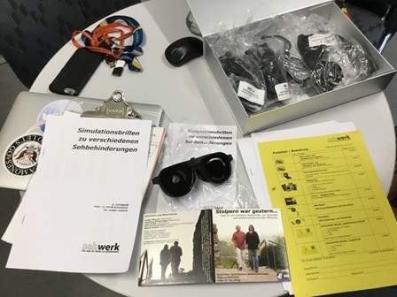 Verschiedene Materialen zur Simulation von Sehbehinderung liegen auf einem Tisch.